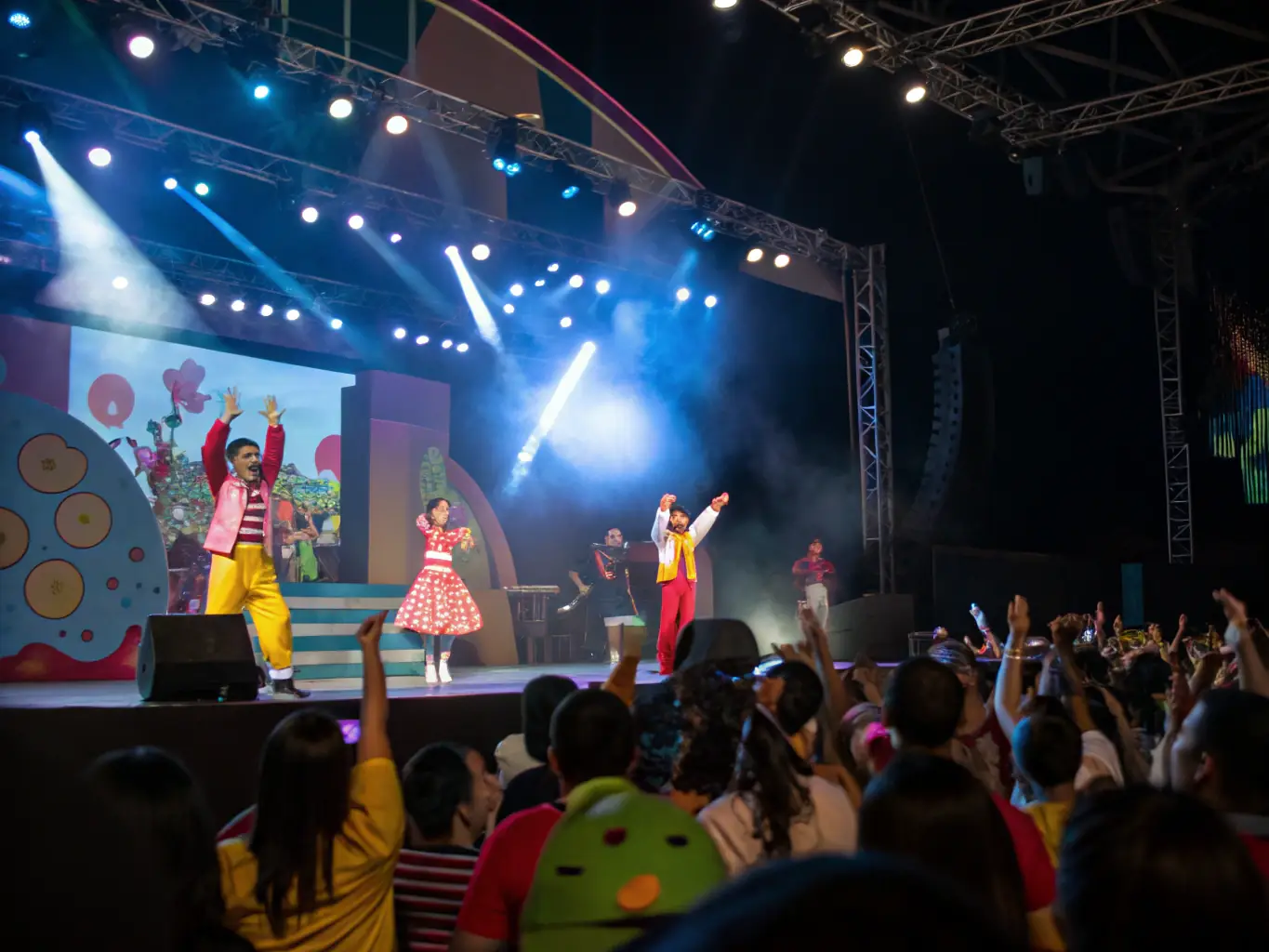 An image of a vibrant community event with artists performing on stage, surrounded by engaged audiences enjoying the spectacle. The scene captures the energy and excitement of a BY VALACROFT cultural event.